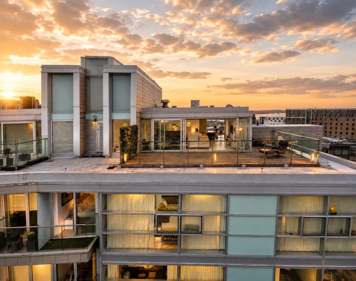 Penthouse roof terrace and glazed living space at sunset, Liverpool city centre