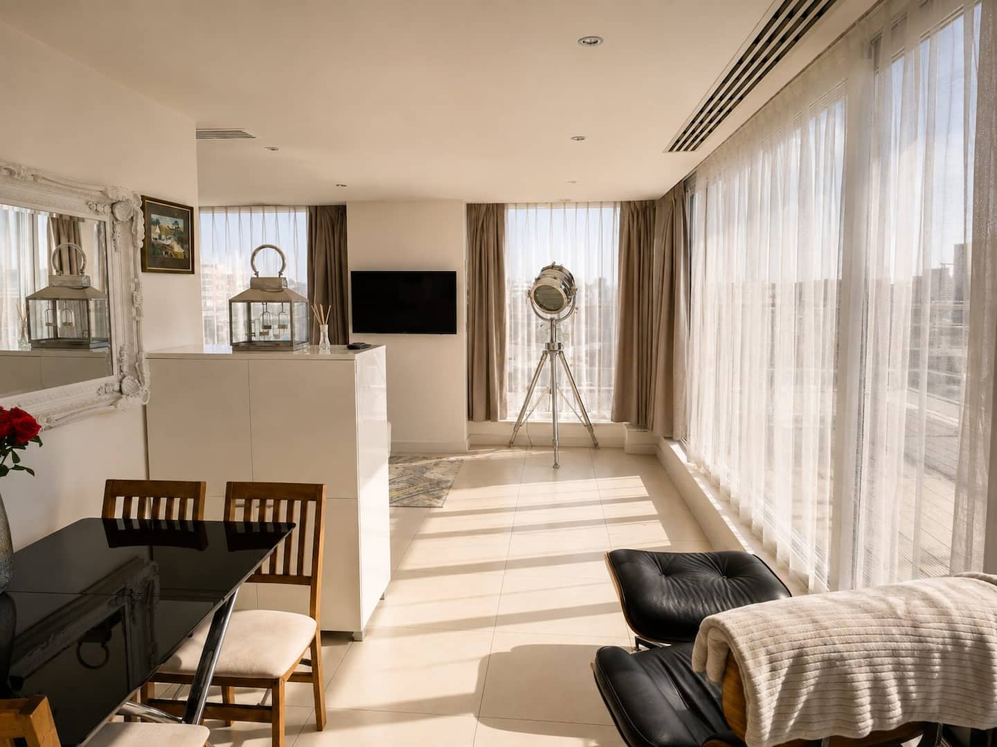 Dining table and lounge chair by the windows of the penthouse