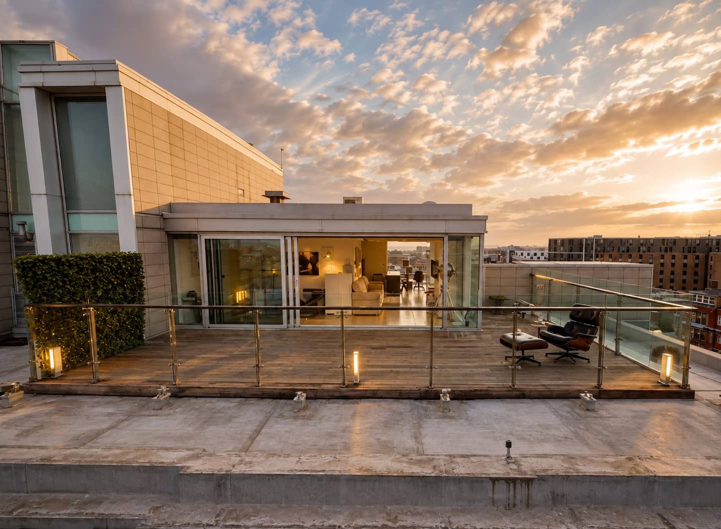 Private roof terrace with glass balustrade at dusk, Liverpool penthouse