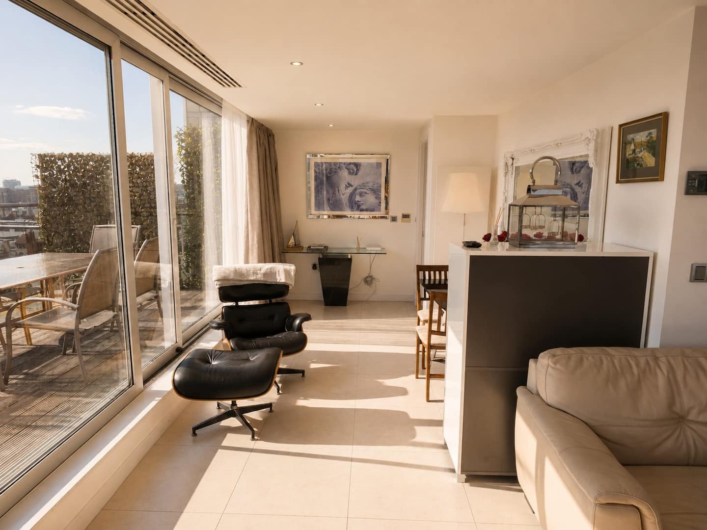 Living area with lounge chairs and terrace doors in the penthouse
